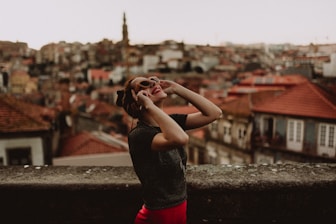 A smiling worker holding a work permit with a European city skyline in the background