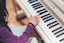 A happy student playing the piano during a lesson.