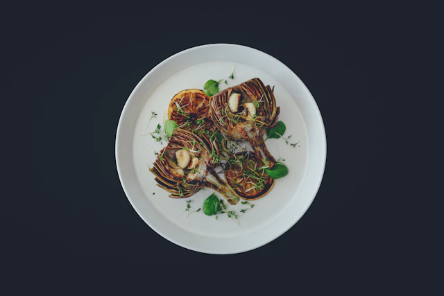 Grilled artichokes on a white plate