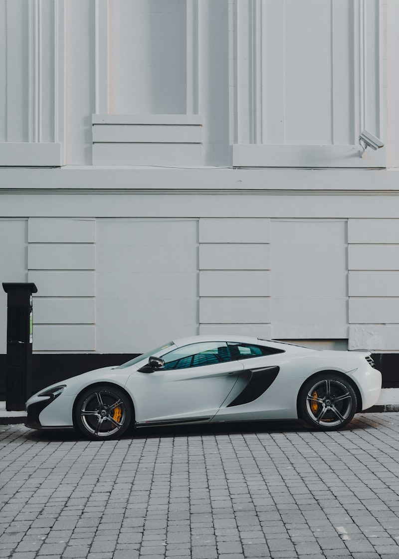 Luxury coupe parked near a clean architectural facade