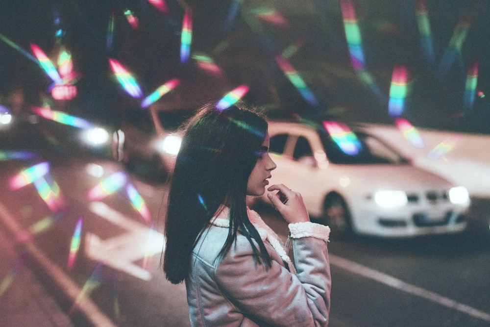 도로에 흰 차 근처에 서 있는 소녀
