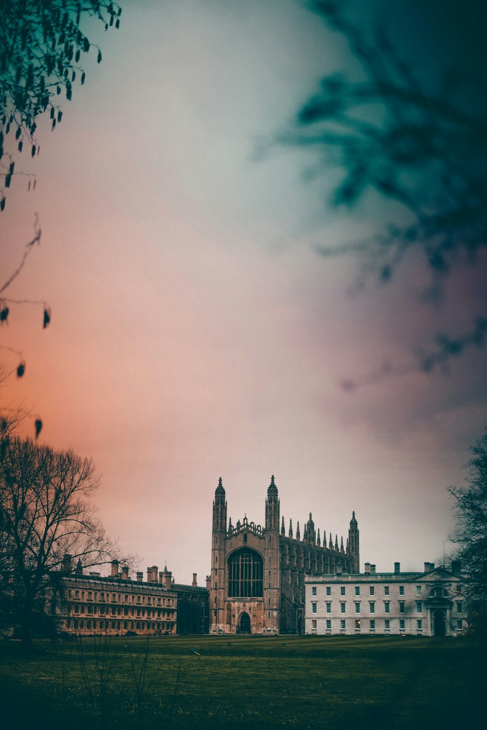 photo of gray concrete cathedral and bare trees under cloudy sky