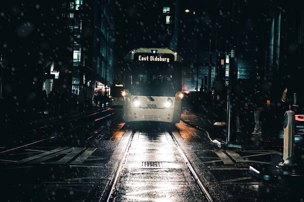 white bus on street during rain