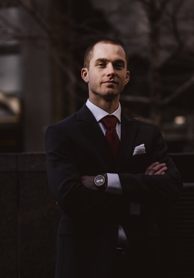 man wearing black notched lapel suit jacket in focus photography