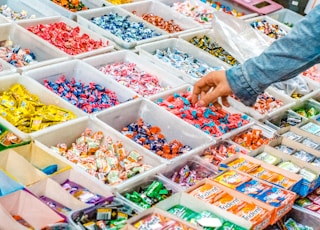 person holding a candy pack on white plastic box