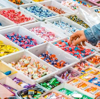 person holding a candy pack on white plastic box