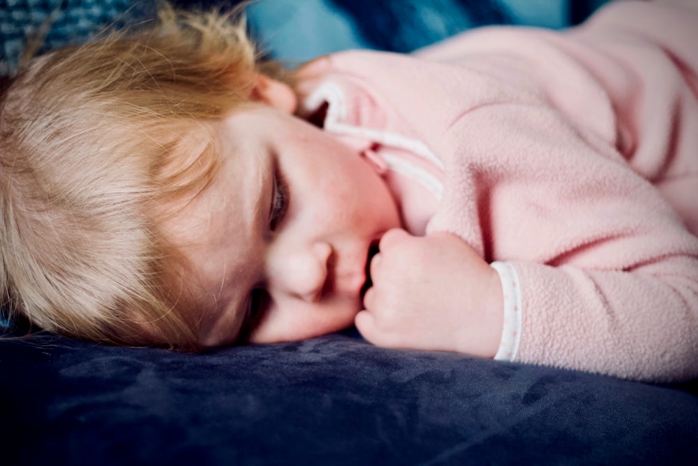 baby sleeping on black surface