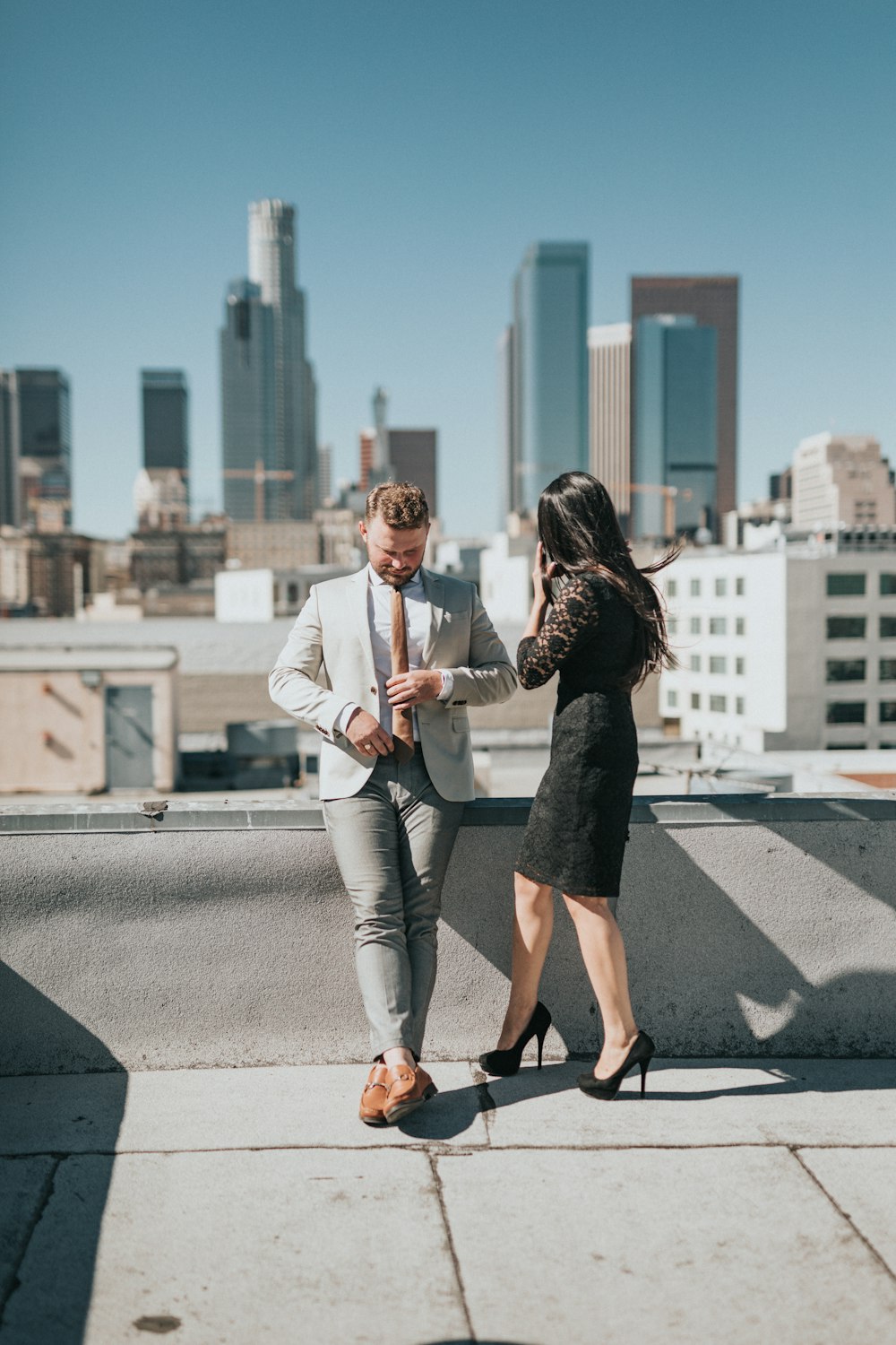 man and woman standing on rooftop of building during daytime