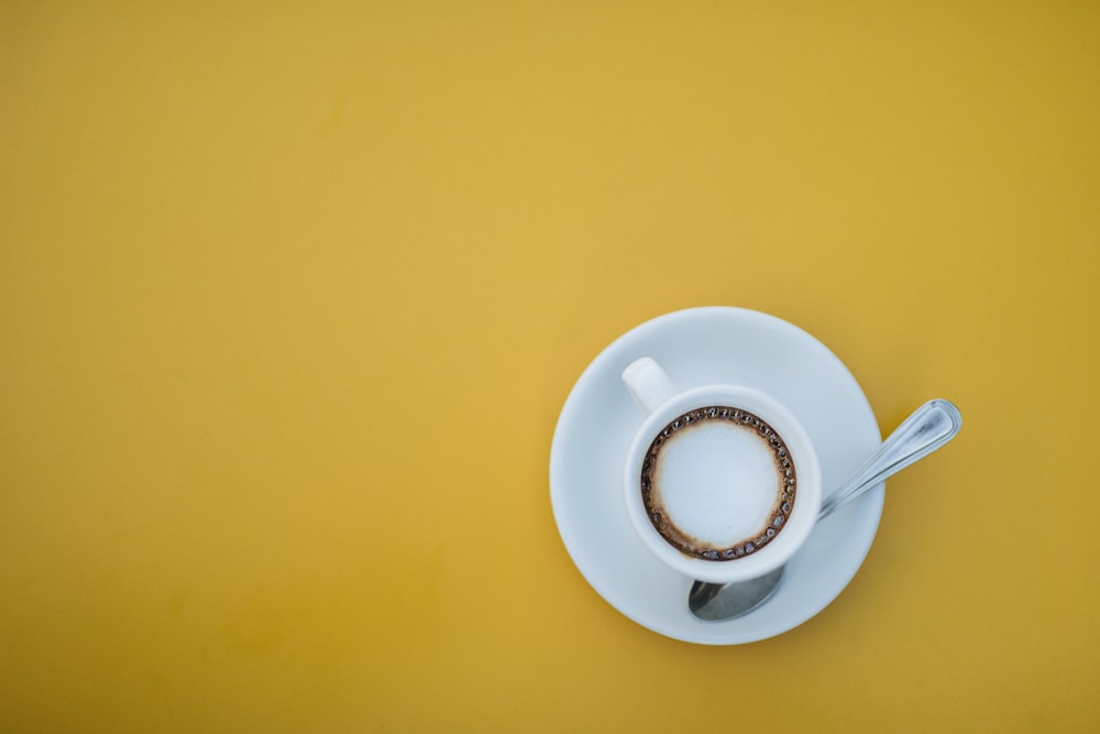 a cup of coffee with a spoon on a saucer