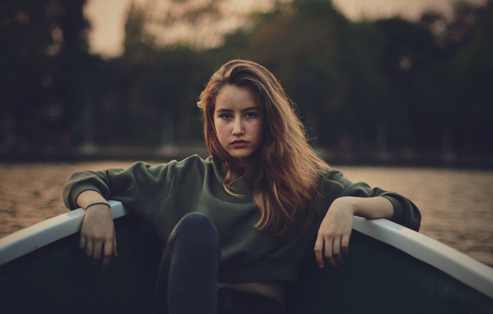 closeup photography of woman wears green sweater on boat