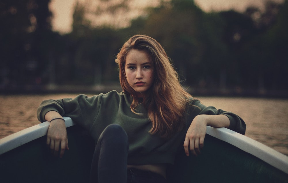 Photographie en gros plan d’une femme portant un pull vert sur un bateau