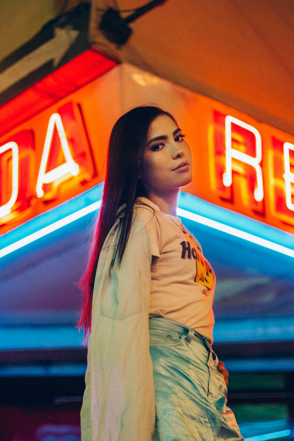 woman standing near red neon light signages