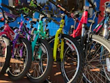 A row of colorful bicycles parked outside a rustic hotel near the Ranong bus station.