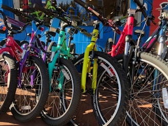 A colorful display of children's bicycles lined up outdoors