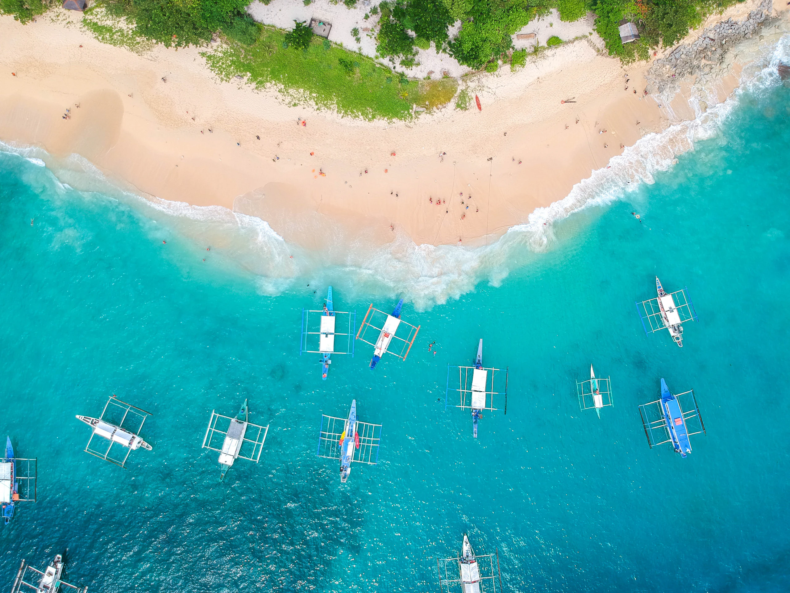 Kayaks drifting into a limestone lagoon in El Nido at sunrise
