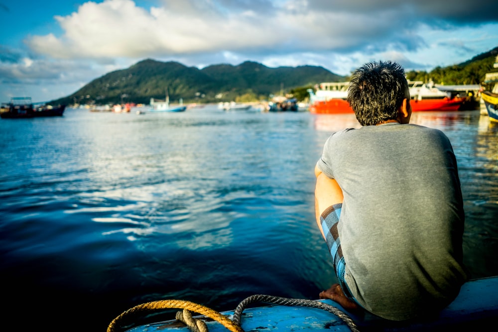 man sitting on boat in body of water