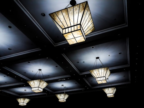 Cluster of small, geometric ceiling lights creating a striking pattern of light and shadow.