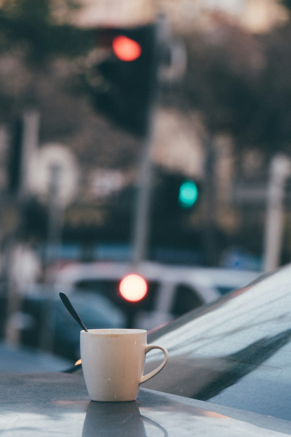 selective focus of white ceramic mugs on vehicle hood during daytime