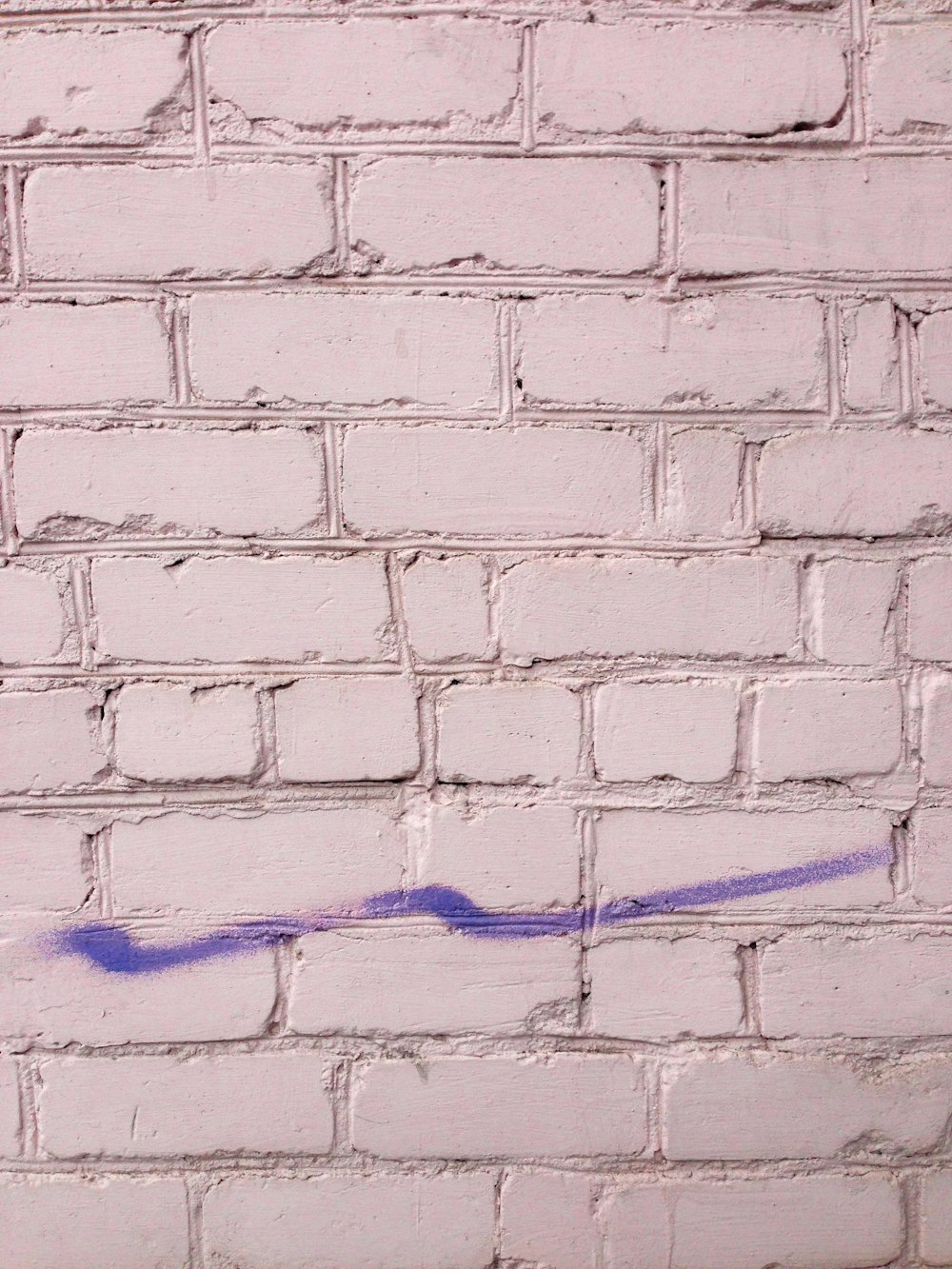 purple painting on white brick