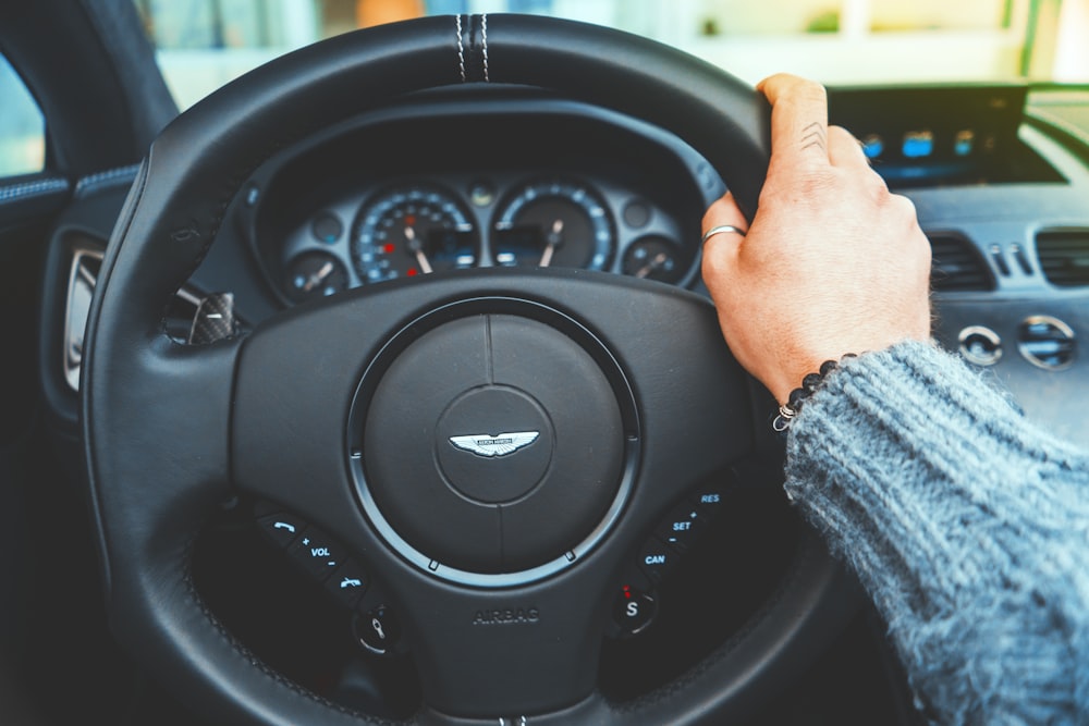 person holding onto a steering wheel