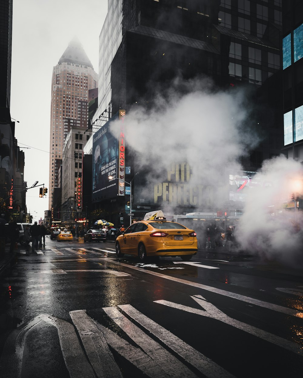 Un taxi sedán amarillo en una calle de concreto gris pasó a través de humos blancos cerca del carril peatonal