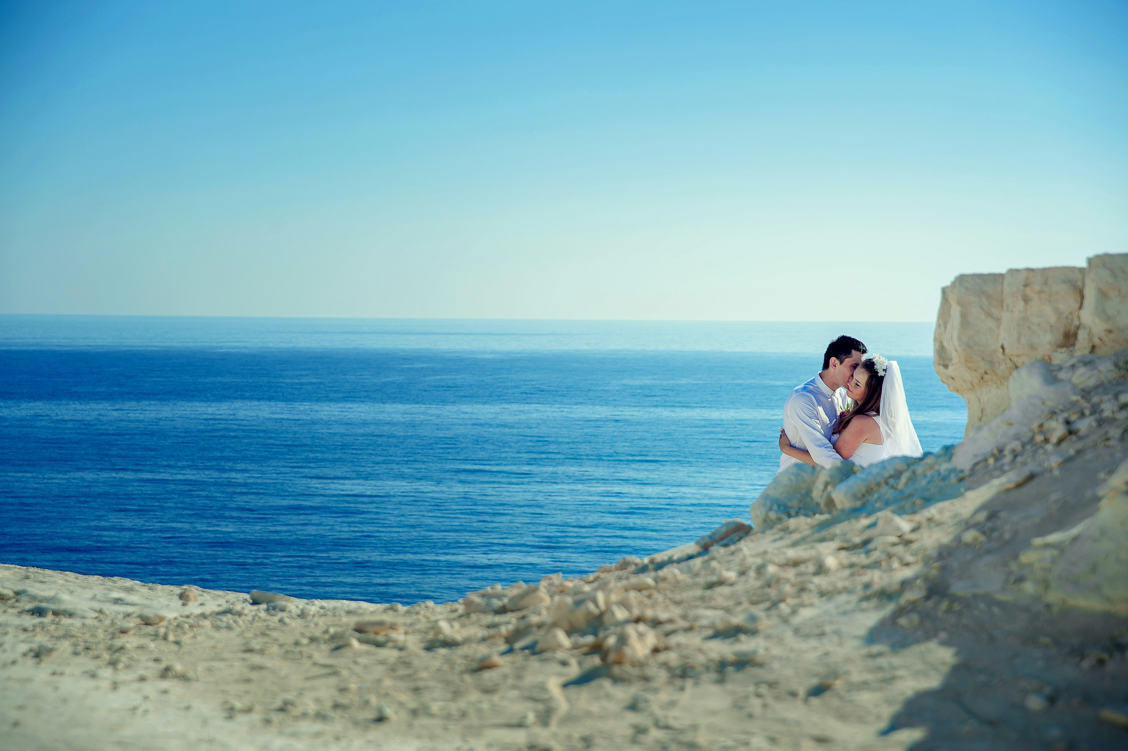 bride and groom near body of water