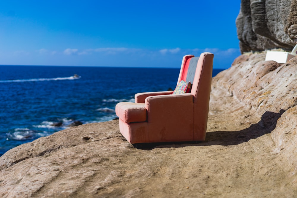 pink sofa chair near body of water