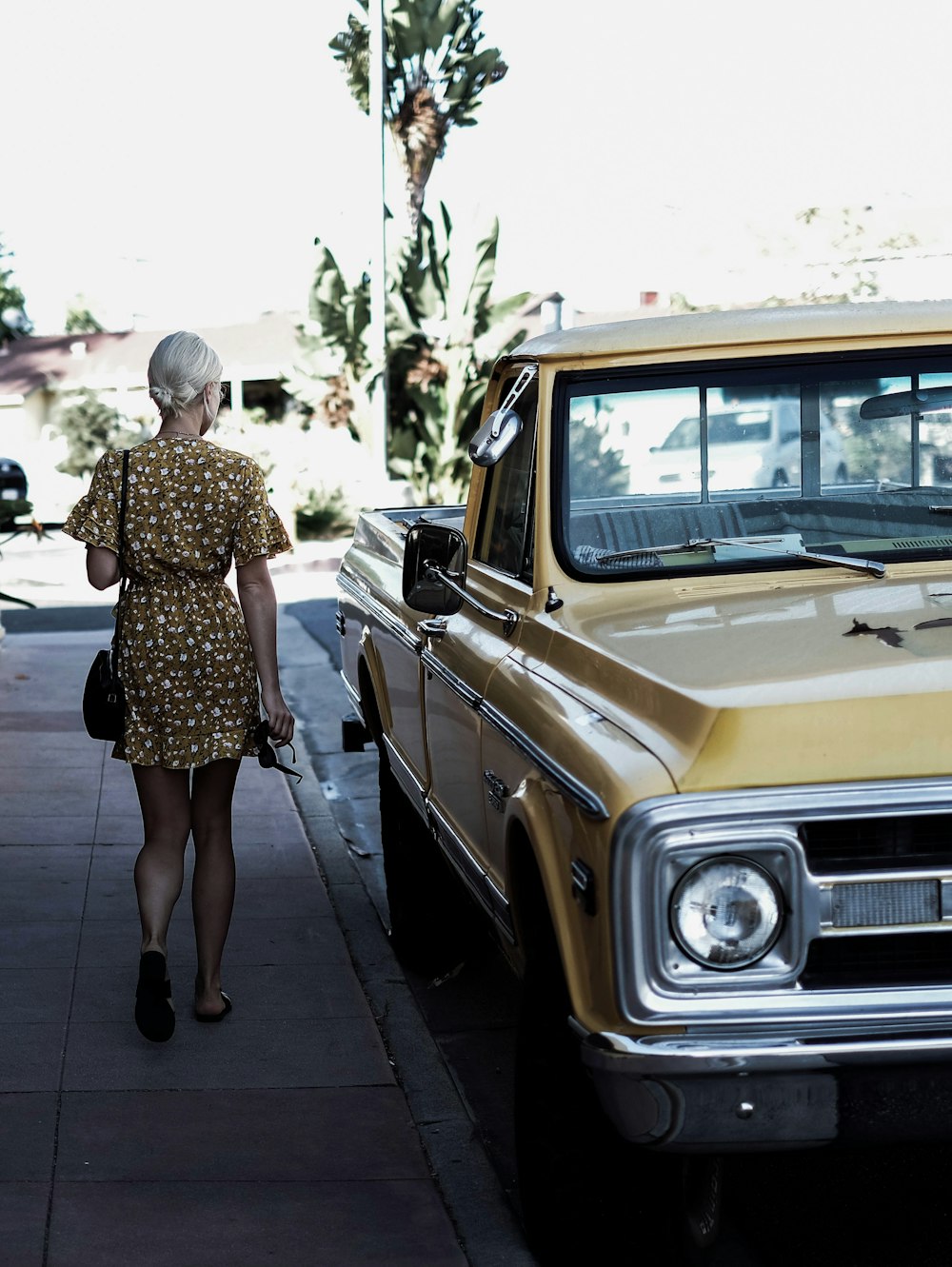 mujer caminando al lado de un coche