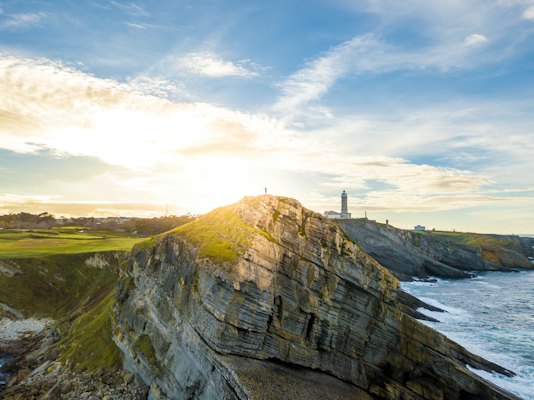 Cliffs and a lighthouse at sunrise — Santander, Spain