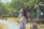 Happy woman using a Redmi A5 smartphone outdoors in a sunny park setting