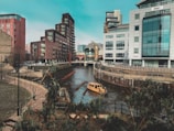 beige boat on body of water between buildings