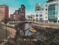 beige boat on body of water between buildings