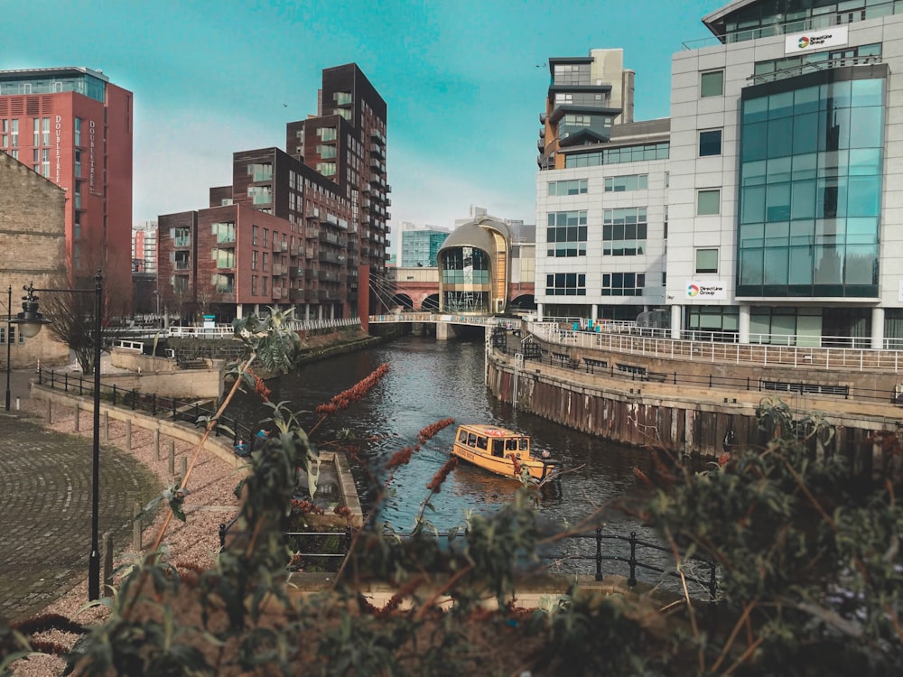 beige boat on body of water between buildings