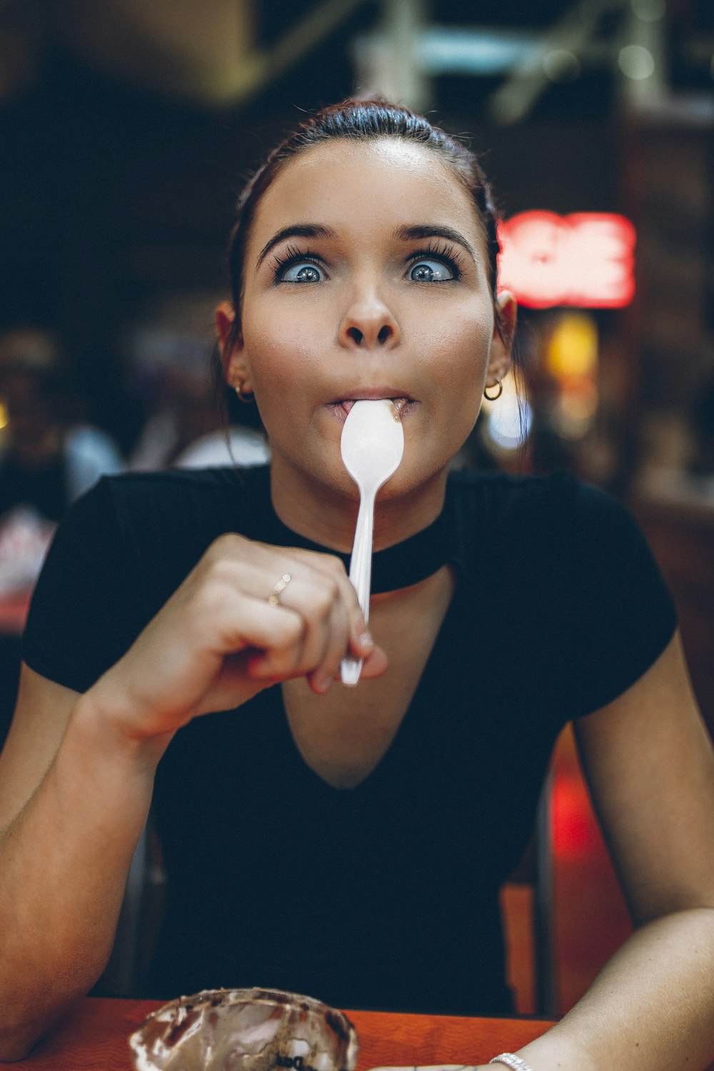 woman holding spoon on tongue