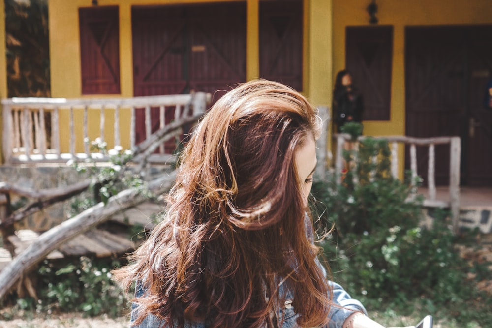 brown haired woman standing in front of yellow building during daytime