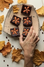 person holding almond topping cookies