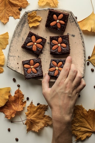 person holding almond topping cookies