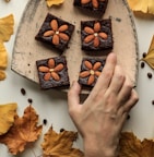 person holding almond topping cookies