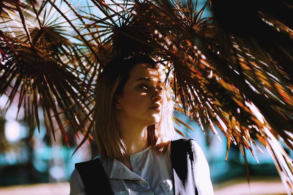 woman looking left under dried leaves