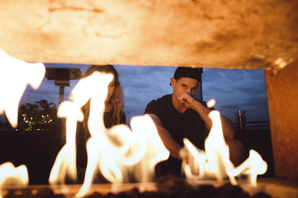 man and woman sitting in front of furnace