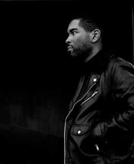 grayscale photography of man wearing leather jacket