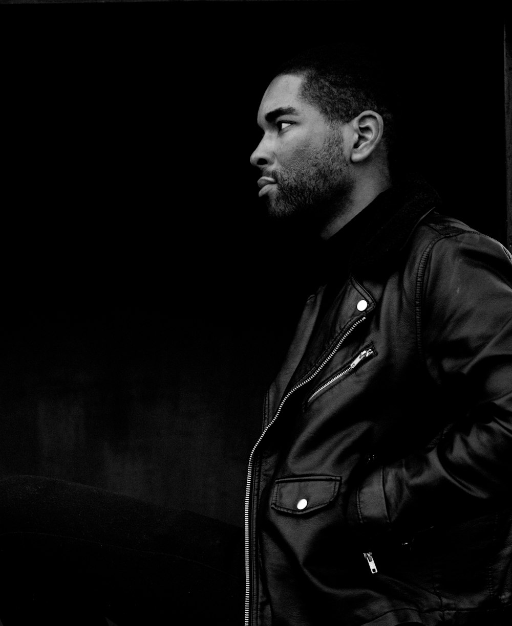 grayscale photography of man wearing leather jacket