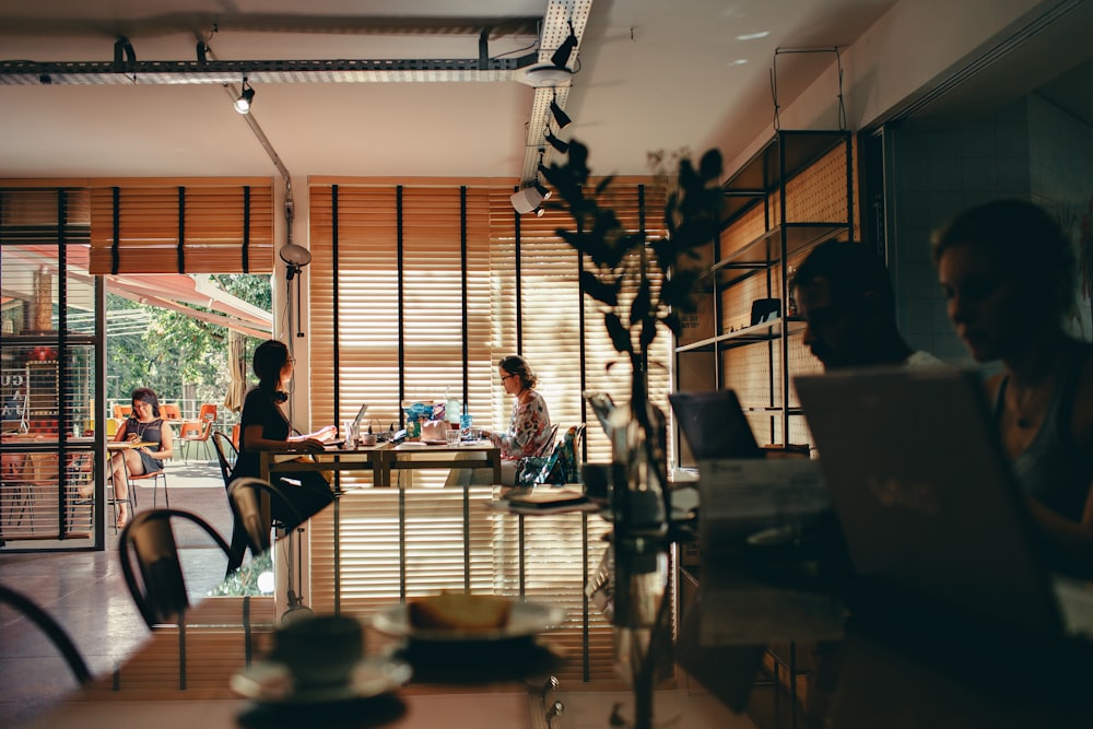 grupo de pessoas sentadas enquanto usam o computador portátil