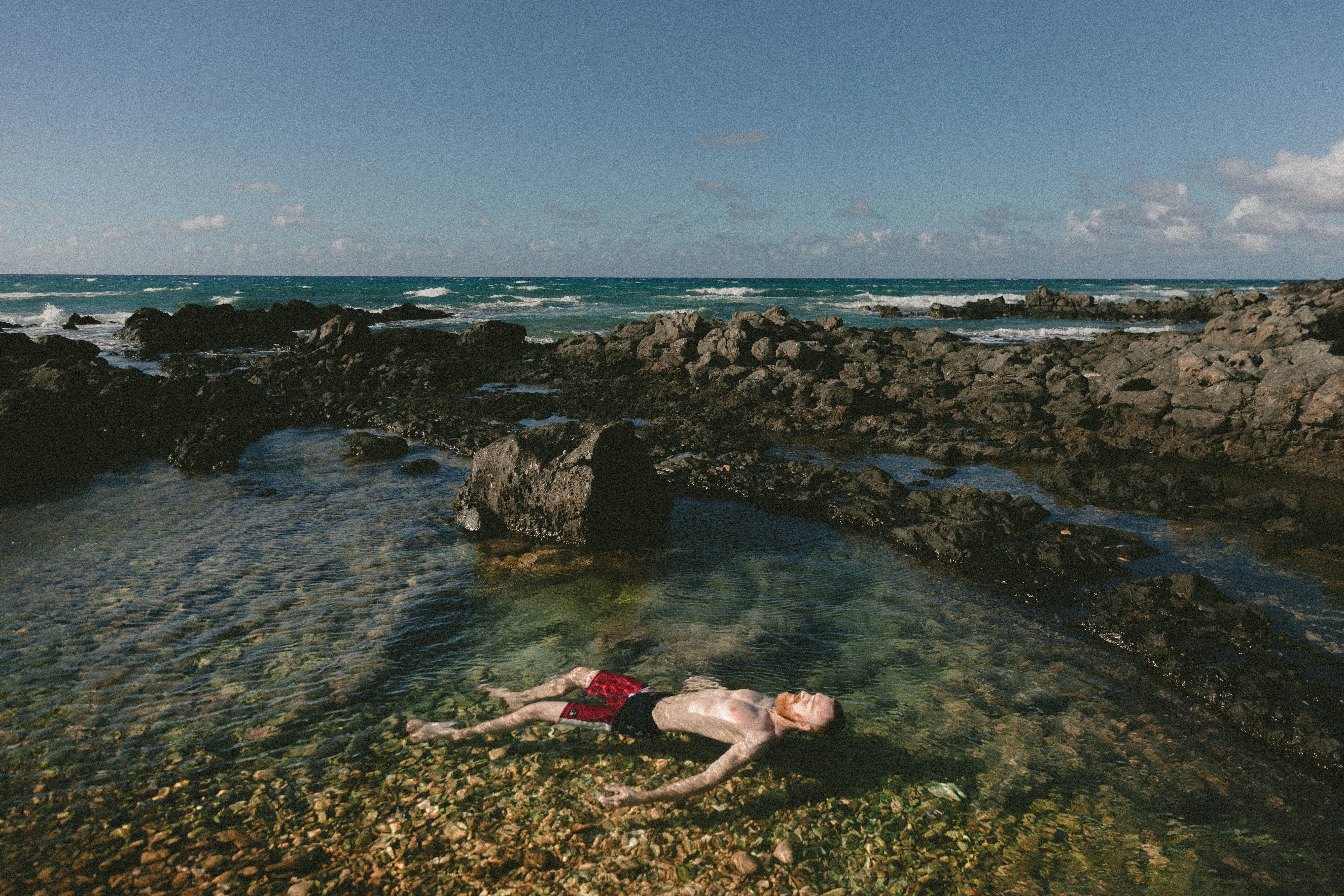 man floating in rockpool
