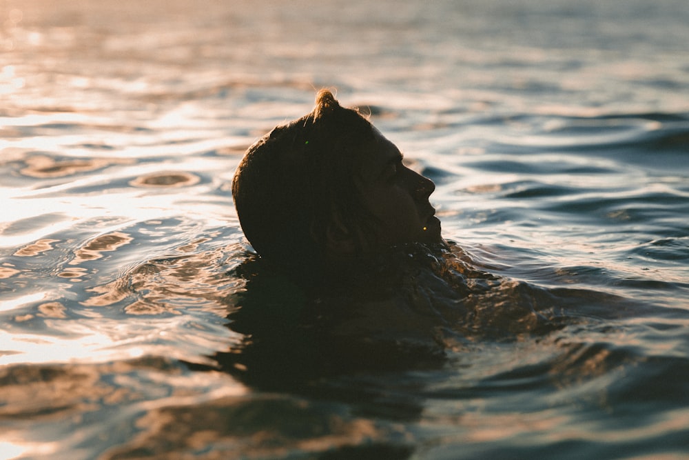 Silhouette einer Person, die auf einem Gewässer schaukelt
