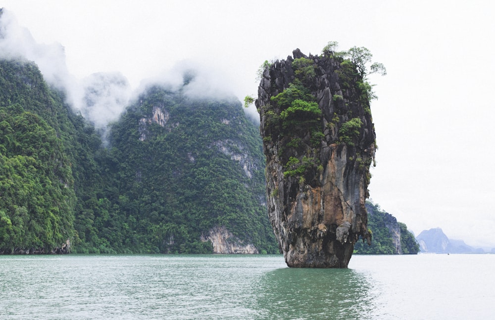 brown rock formation on body of water during daytime