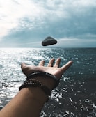 A bracelet displayed on a hand reaching out into a swirling nebula of stars and deep space motion.