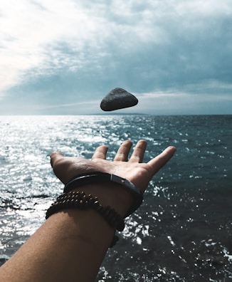 A bracelet displayed on a hand reaching out into a swirling nebula of stars and deep space motion.