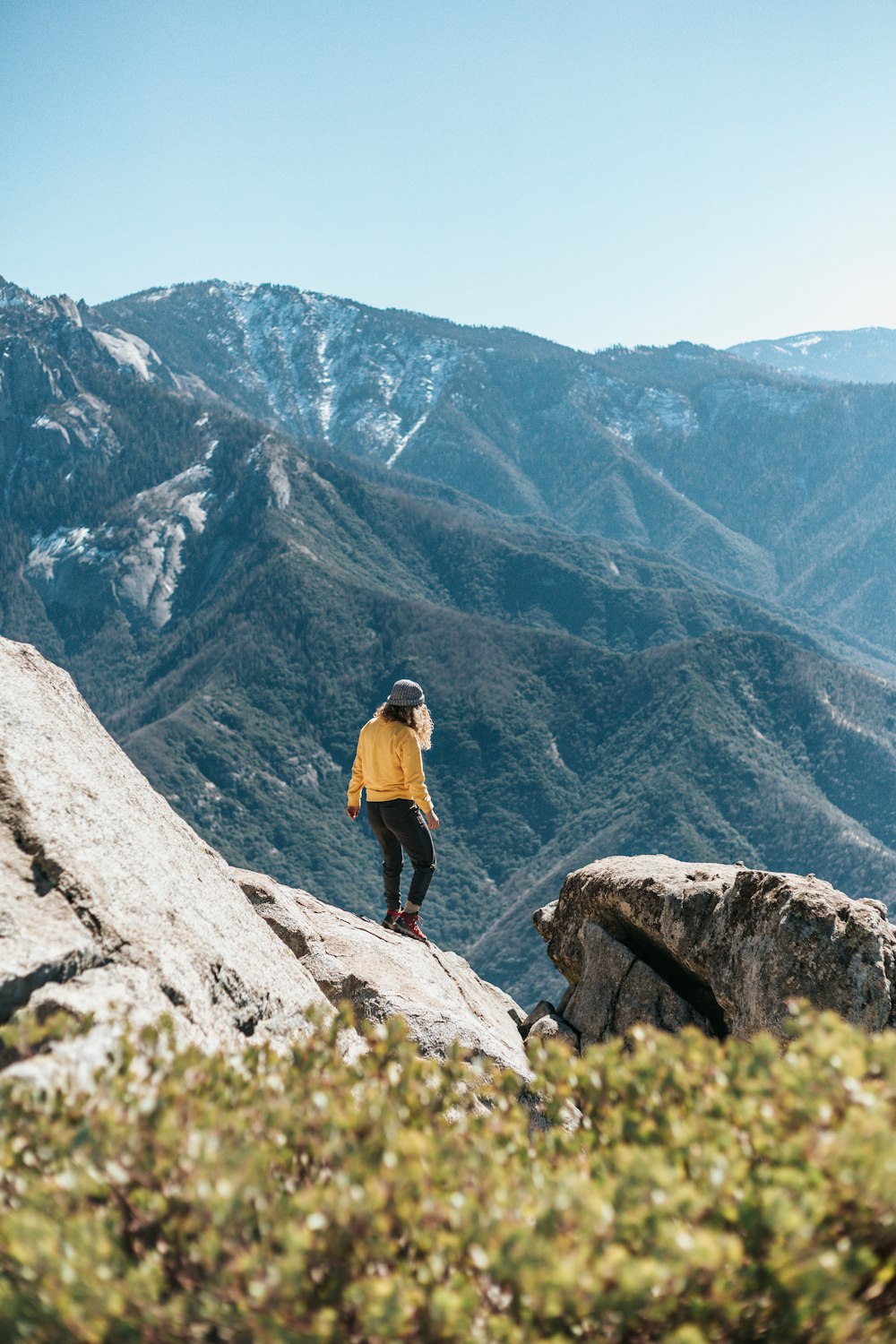 a woman standing on the edge of a cliff