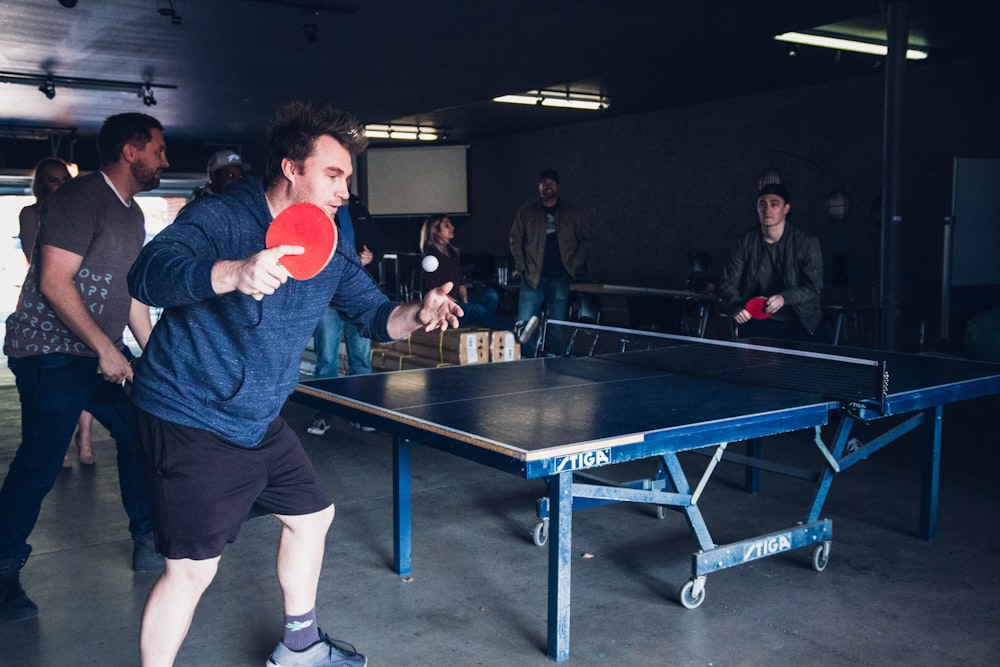 a man holding a ping pong paddle in his hand